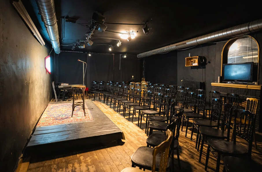 Amai Comedy Club upstairs room — rows of chairs facing the stage