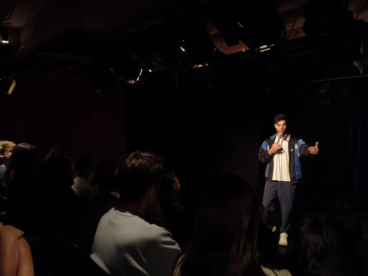 A comedian performing in front of the seated audience at Theater Box in Ghent.